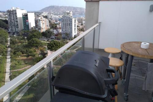 a chair on a balcony with a view of a city at Barranc Group Penthouse in Lima
