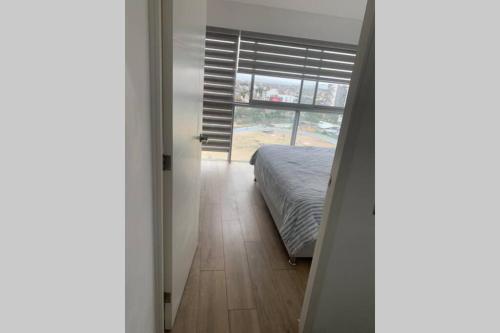 a bedroom with a bed and a large window at Barranc Group Penthouse in Lima