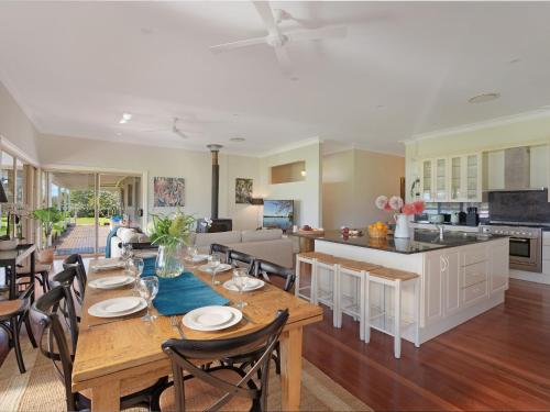 a dining room and kitchen with a table and chairs at Terara Riverview Estate in Terara