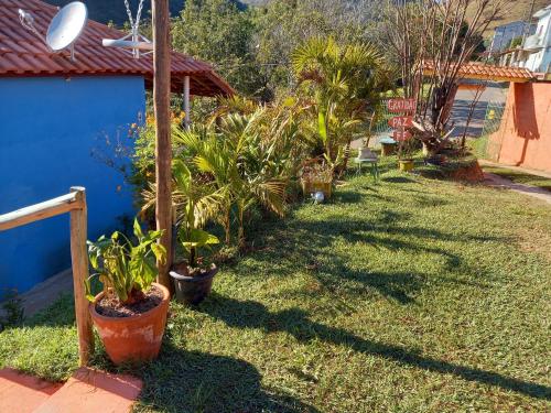 a yard with potted plants on the grass at Chalés Encantos de Cunha Azul in Cunha