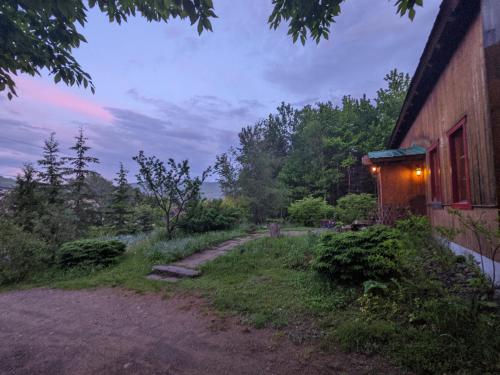 a house with a dirt road next to a building at Cottage Jacques Cartier in Stoneham