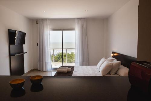 1 dormitorio con cama y ventana grande en Mar del Este en San Bernardo