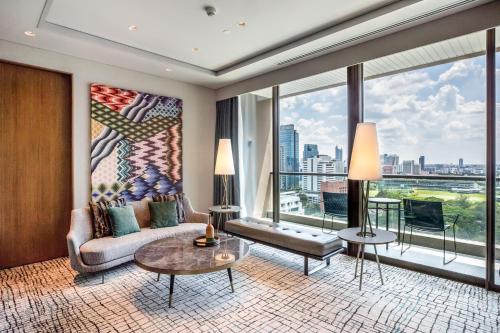 a living room with a couch and a large window at Kimpton Maa-Lai Bangkok, an IHG Hotel in Bangkok