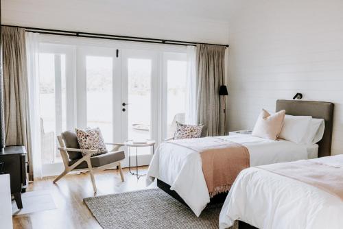 a bedroom with two beds and a chair and a window at The Homestead in Berry