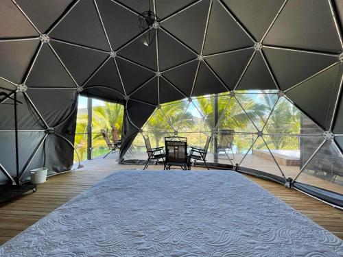une grande tente avec une table et des chaises. dans l'établissement Glamping Montecarlo Domo Geodesico y Sauna Finlandés Guatapé, à Guatapé