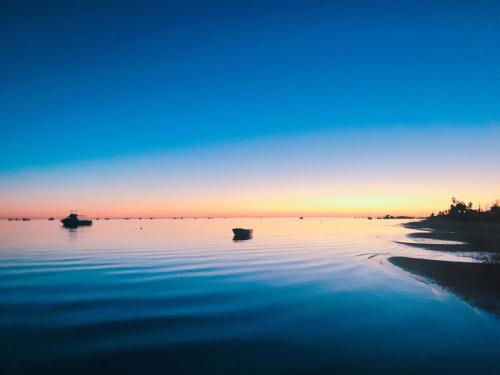 a group of boats on the water at sunset at Bay Lodge in Denham