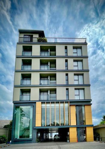 a tall white building with a lot of windows at M2 Hotel Waterside in Phayao