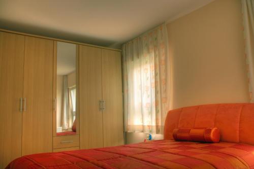 ein Schlafzimmer mit einem Bett mit einer orangefarbenen Bettdecke in der Unterkunft Apartment am Großen Garten Dresden in Dresden