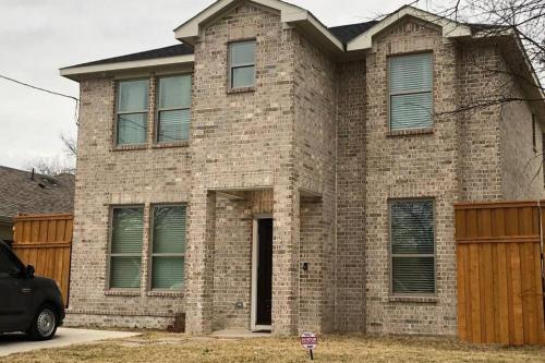 a brick house with a car parked in front of it at Dallas 4BR Large yard w HOT TUB , Fire pit and basketball Hoop in Dallas