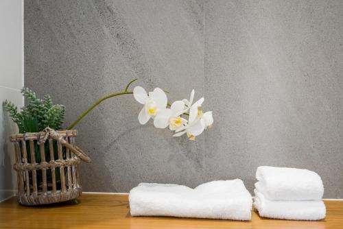 a table with towels and a vase with flowers at Foam in Byron Bay