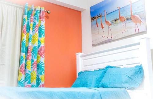 金斯敦的住宿－Royal Bliss Apartment Suites，一间卧室设有橙色的墙壁和一张带婴儿床的床