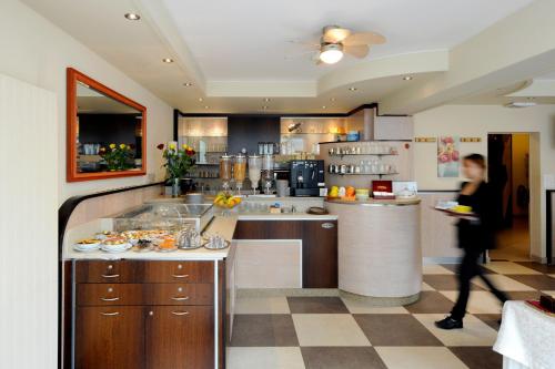 a woman walking through a kitchen with a counter at Bon Port in Montreux