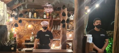 two men wearing face masks standing in a bar at Hotel Villas Tiburon in Holbox Island