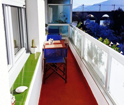 a balcony with two blue chairs and a table on it at Vivienda Turístico Erreka Beach in Mundaka