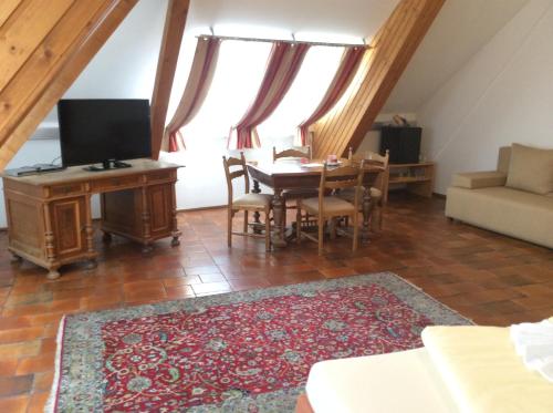 a living room with a table and a tv at Stadthotel Schwerterbräu in Judenburg