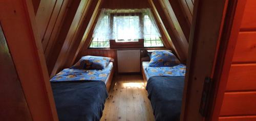 A bed or beds in a room at Domki Brenna Leśnica