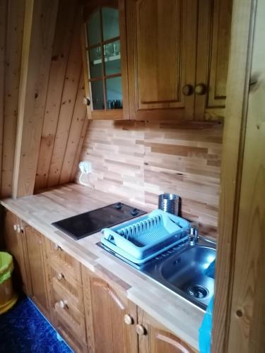 a kitchen sink with a blue tray on top of it at Domki Brenna Leśnica in Brenna