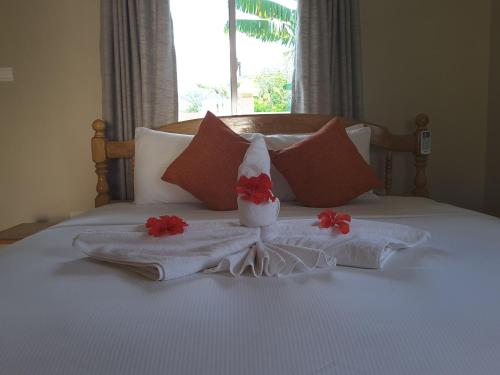 a bed with a santa hat and flowers on it at Villa Aya in Grand'Anse Praslin