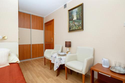 - un salon avec une table, des chaises et un lit dans l'établissement Willa u Wójta, à Pobierowo