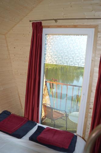 a bedroom with a window with a view of a deck at Metsjärve mini puhkemaja in Põlva
