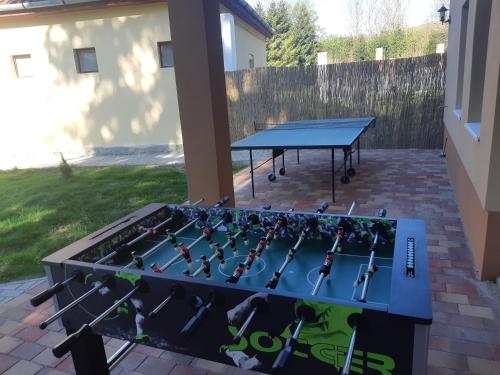 a grill with a ping pong table in a backyard at Fónagy Apartmanok in Nagyvisnyó