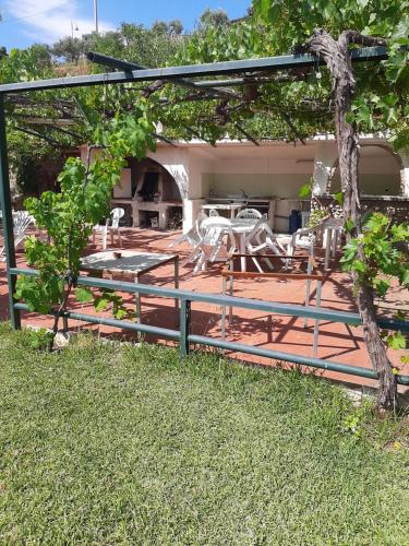a patio with a fence and a table and chairs at Hotel Conca d'Oro in Stalettì
