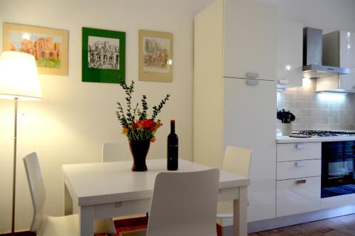 una cucina bianca con tavolo e bottiglia di vino di Il Limone A San Pietro a Roma