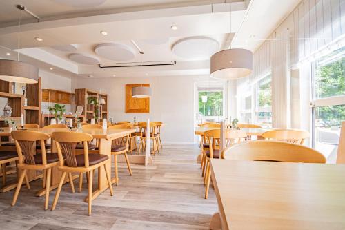 a restaurant with wooden tables and chairs at Landhotel Ringelsteiner Mühle in Moselkern