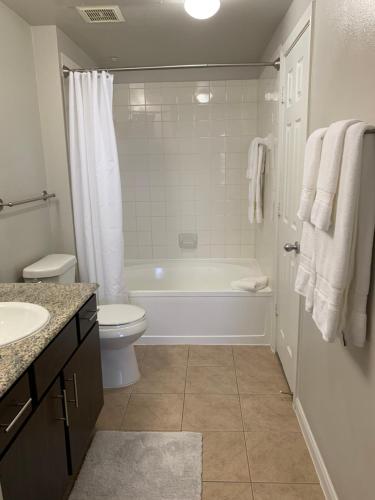 a bathroom with a tub and a toilet and a sink at Newly Furnished 1BR Apartment w/ Hermann Park View in Houston