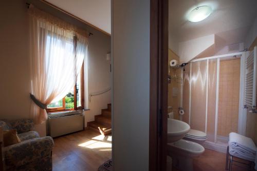 a bathroom with a toilet and a sink and a window at Villa Scacciapensieri Boutique Hotel in Siena