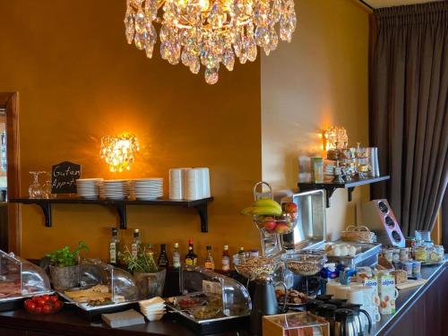 a restaurant with a buffet of food and a chandelier at Hotel Niedersachsen in Quakenbrück