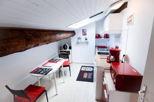 une petite cuisine avec une table et un appareil rouge dans l'établissement STUDIO 9 Classé 2 Etoiles, à Carcassonne