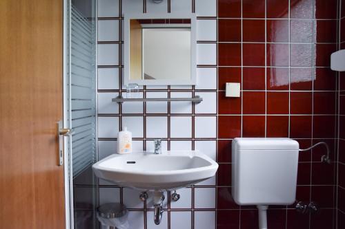 a bathroom with a sink and a mirror and a toilet at Mads Hotel in Cologne