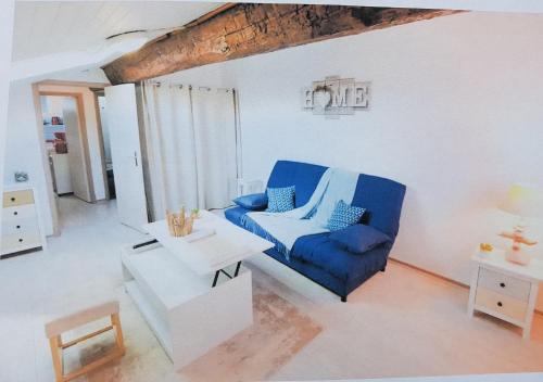 un salon avec une chaise bleue et une table dans l'établissement STUDIO 9 Classé 2 Etoiles, à Carcassonne