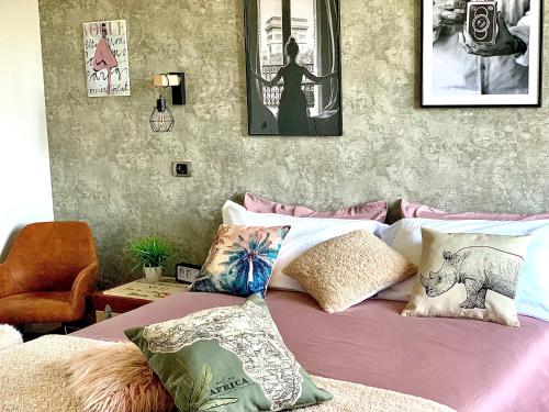 Schlafzimmer mit einem Bett mit Kissen und Bildern an der Wand in der Unterkunft Goose House Luxury Holiday Home in Sutri