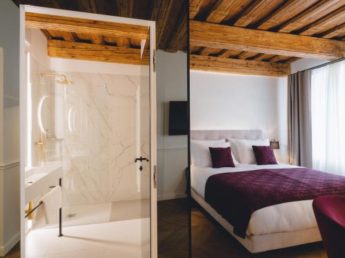 a bedroom with a king sized bed and a bathroom at Hotel Heritage in Ljubljana