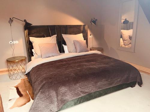 a large bed with a brown blanket and pillows at Gutshaus Klein kussewitz in Klein Kussewitz