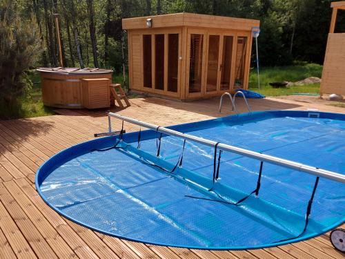 una gran piscina en una terraza con una casa en Dom przy lesie en Wielgie