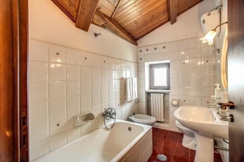 a bathroom with a tub and a sink and a toilet at Hotel Sant'Angelo Al Belvedere in Vico Equense