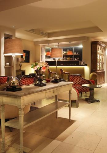 un salon avec une table avec des fleurs dessus dans l'établissement Résidence Hôtelière 4 étoiles Les Mas du Grand Vallon, à Mougins