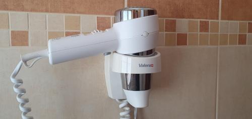a white hair dryer hanging on a wall at Hotel Karlštejn & SPA in Karlštejn