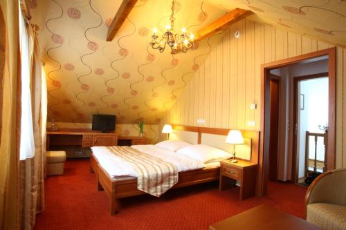 a bedroom with a bed and a chandelier at Penzion Otakar in Polička