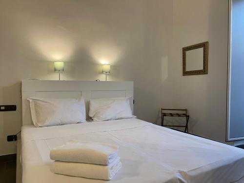 a bedroom with a white bed with towels on it at Jazz Hotel in Naples