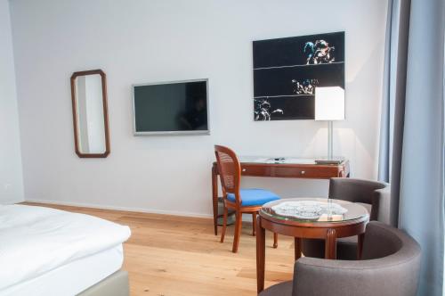 a hotel room with a desk and a bed at Hotel Beau Rivage Weggis in Weggis