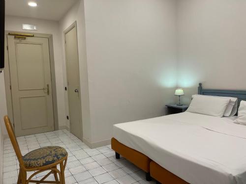 a bedroom with a large bed and a chair at Jazz Hotel in Naples