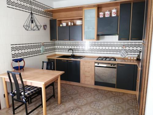een keuken met een houten tafel en een tafel en stoelen bij Casa vacanze Donatella in Carenno