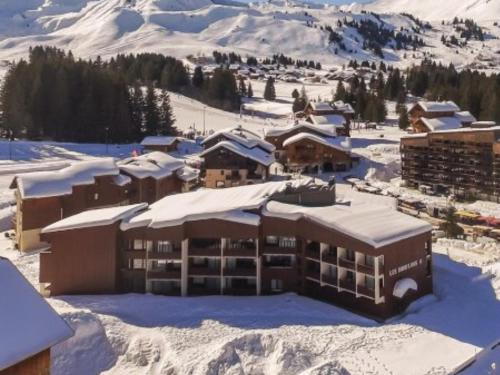 ein schneebedecktes Gebäude mit einem Berg im Hintergrund in der Unterkunft studio cabine Praz de Lys in Taninges