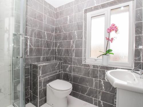 łazienka z toaletą, umywalką i oknem w obiekcie Tidal Drift w mieście Weymouth