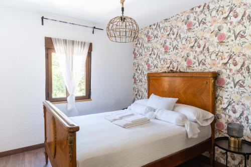 Schlafzimmer mit einem Bett mit Blumentapete in der Unterkunft Housingleón - Atico Gaudí in León
