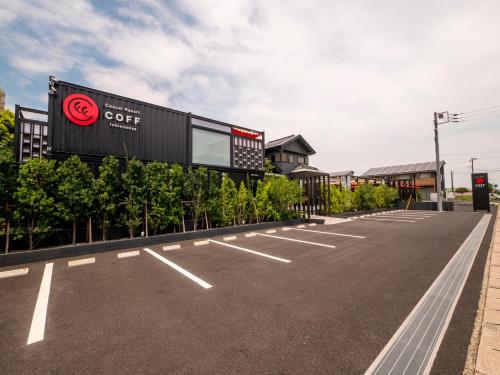an empty parking lot with a sign for a coffee store at HOTEL R9 Kujukuri "ex Casual Resort COFF Ichinomiya" in Ichinomiya